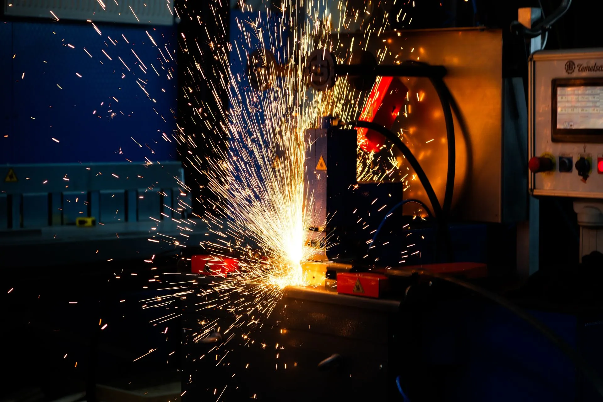 Bright arc-welding sparks flying from a steel joint in a fabrication shop